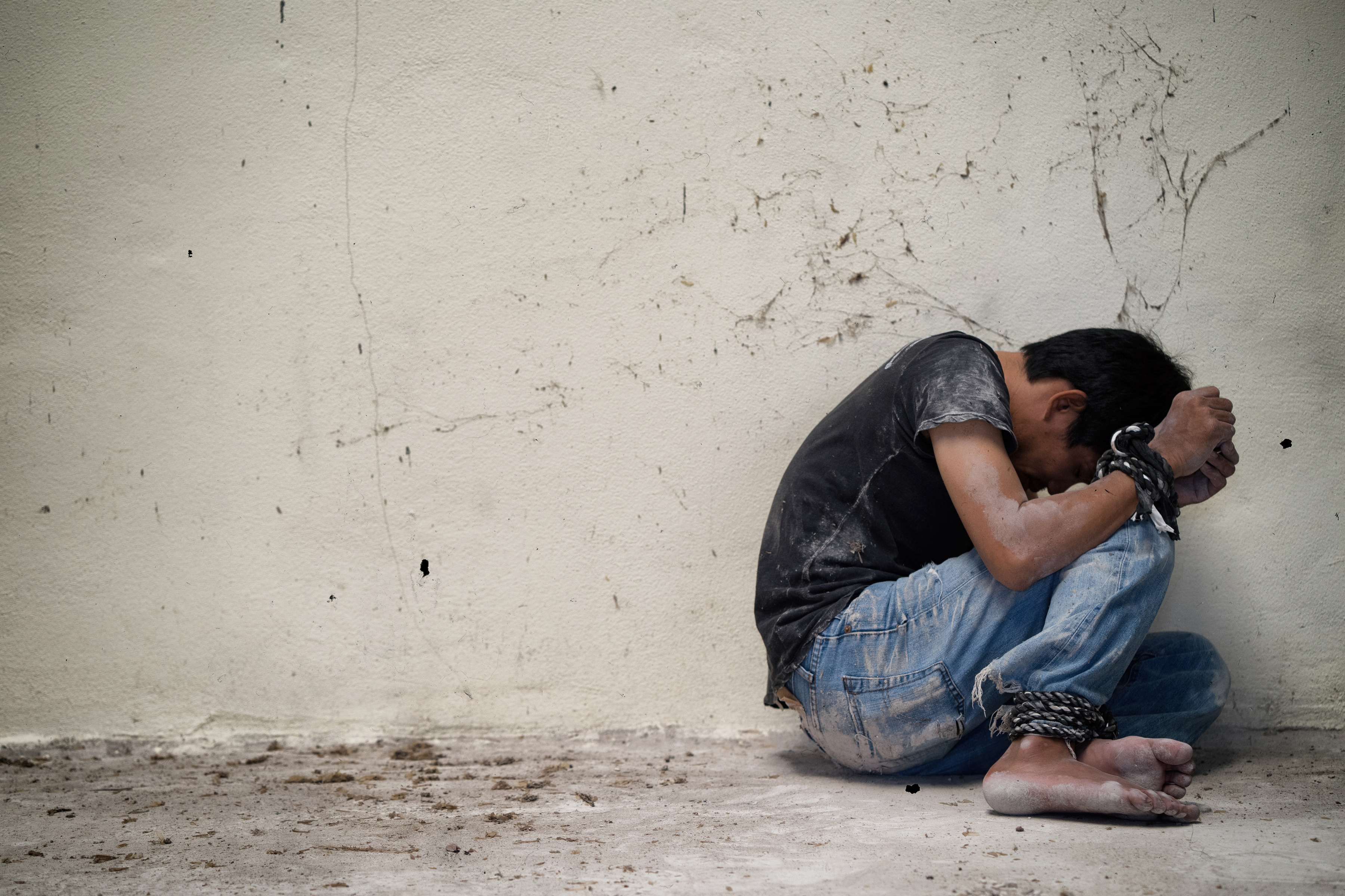 hopeless man hands tied together with rope